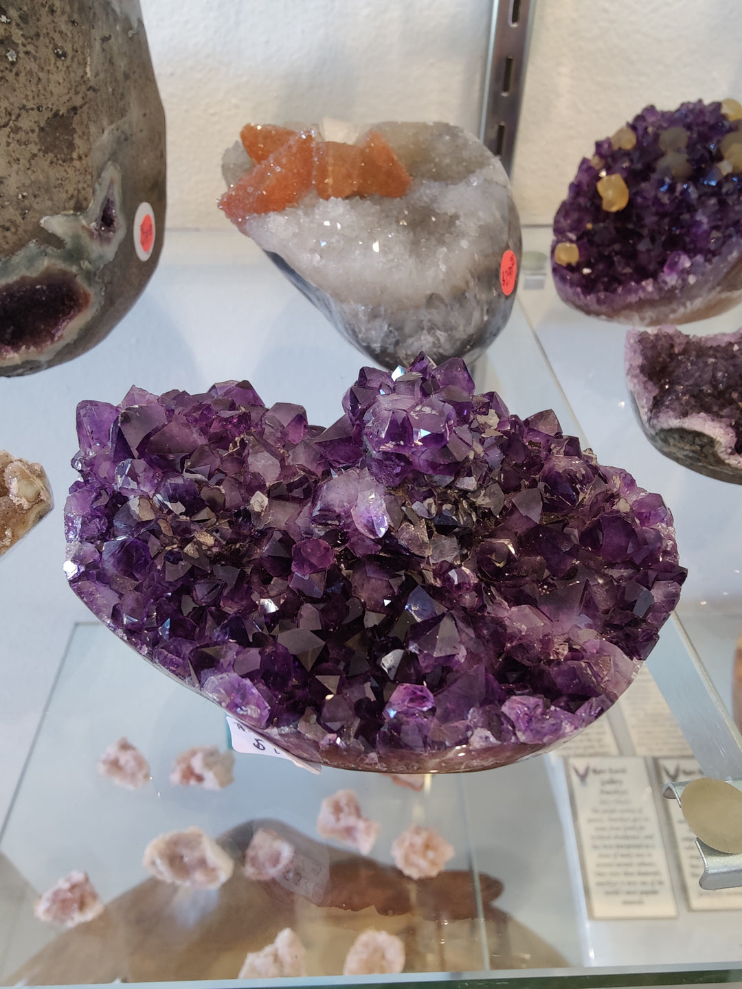 Amethyst flower-formation crystal geode cluster in a purple heart-shaped display dish