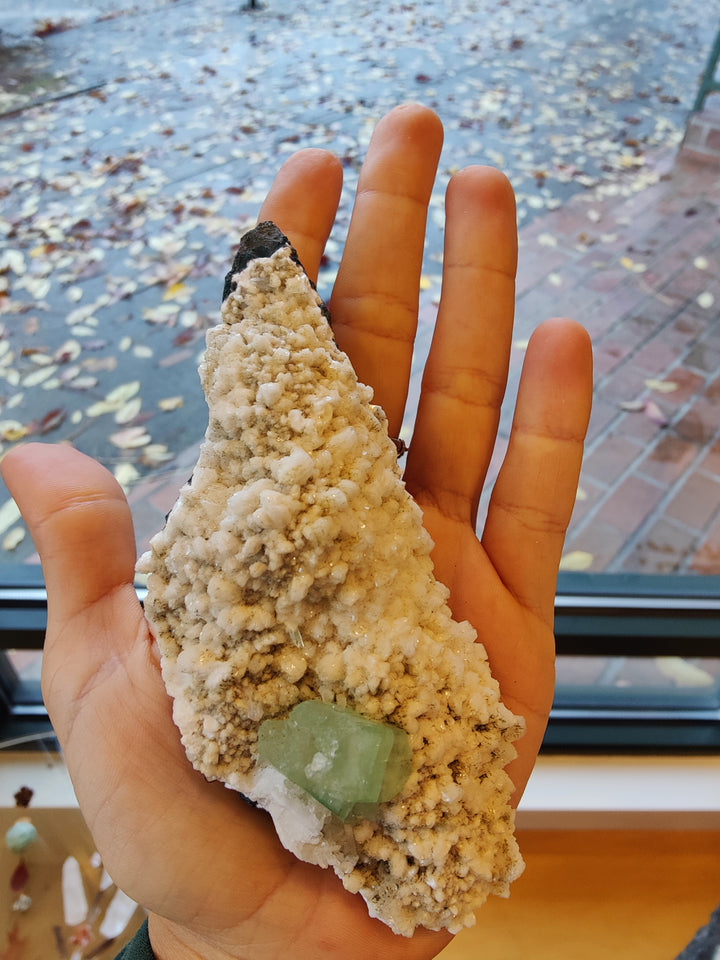 Mineral specimen with beige matrix and pale green crystal cluster