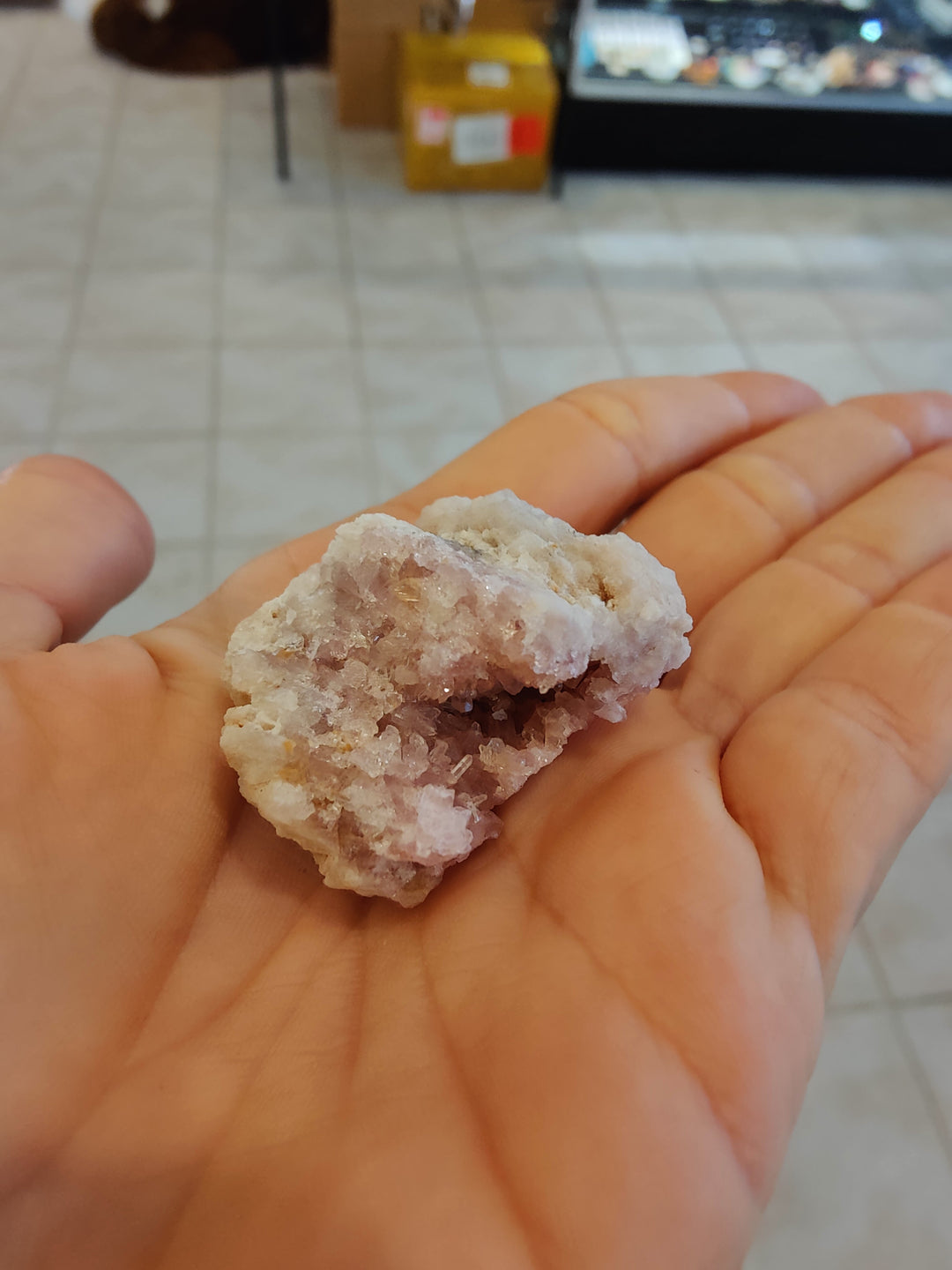 Rough pink amethyst crystal in hand, with white matrix and pink crystal points