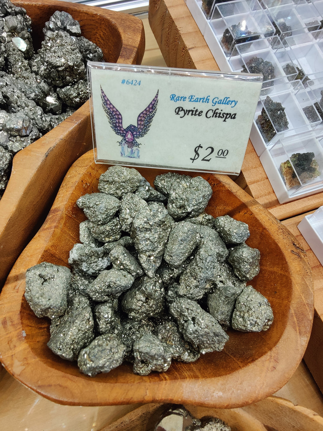 Dark gray pyrite ore nuggets in a wooden tray