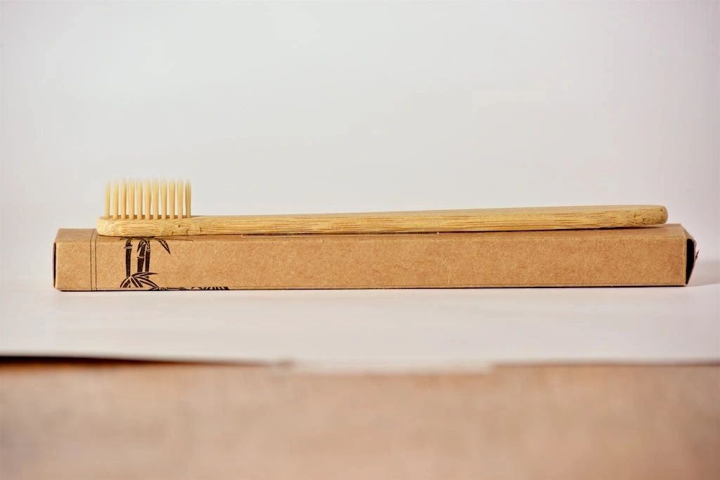 Bamboo toothbrush with soft bristles inside cardboard sleeve package