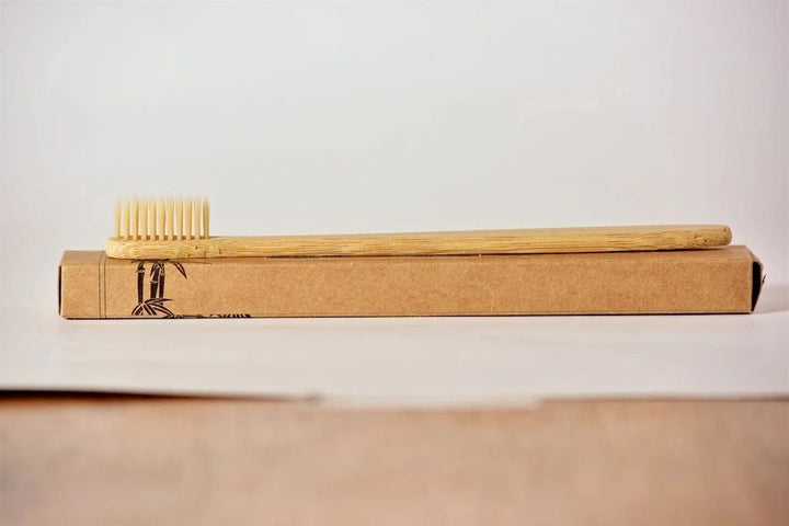 Bamboo toothbrush with soft bristles inside cardboard sleeve package