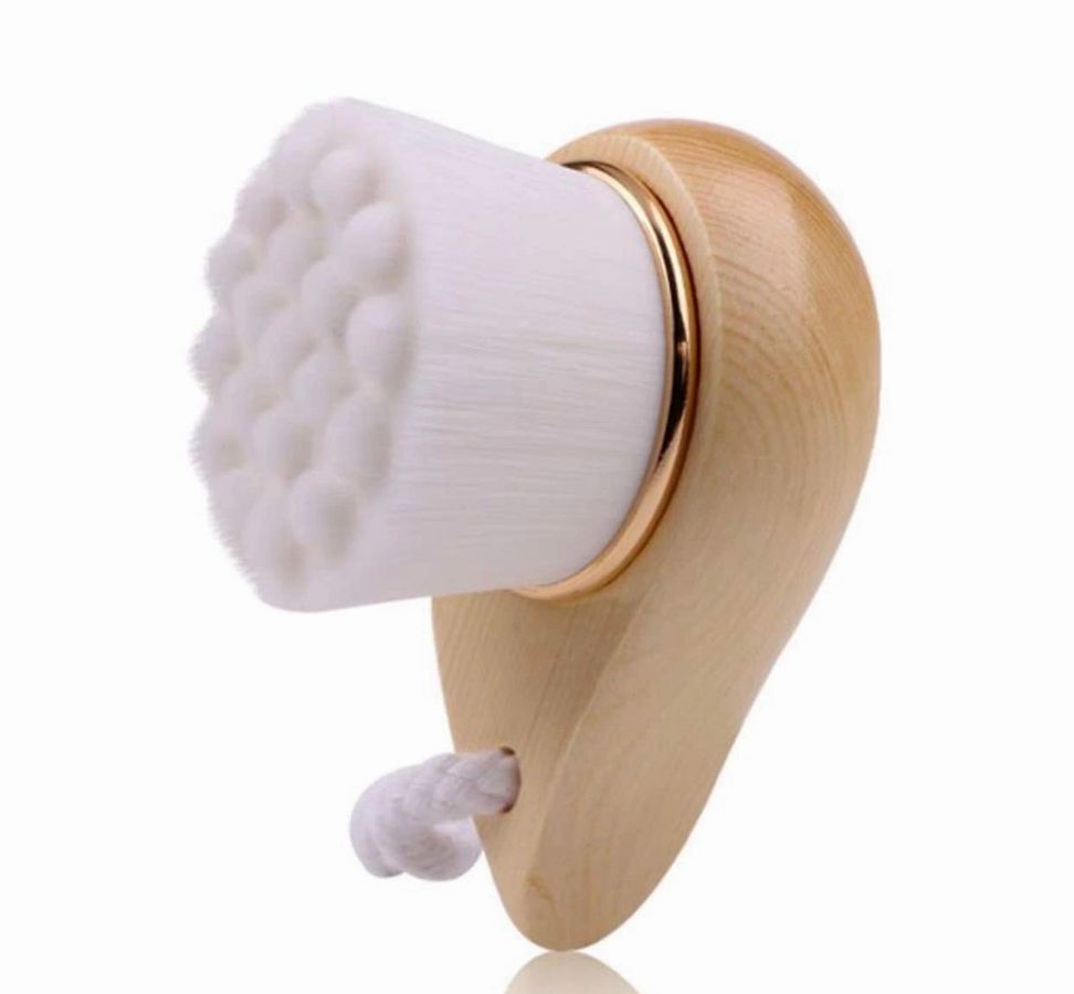 Wooden-handled facial brush with white textured bristle pad