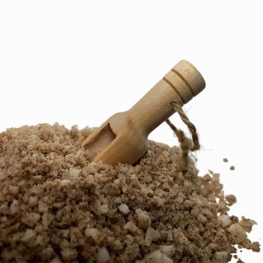 Close-up of bath and foot soak granules spilled from a small wooden scoop