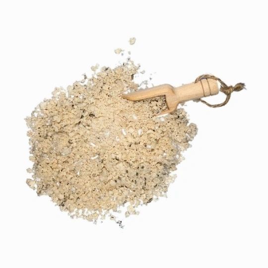 Pile of bath and foot soak granules with wooden scoop above
