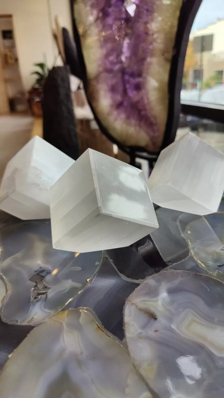 Set of translucent selenite standing cubes arranged on a dark surface