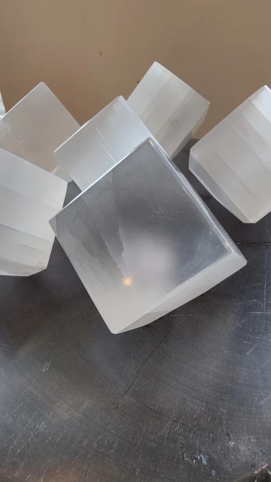 Cluster of translucent selenite standing cubes with beveled edges on tabletop