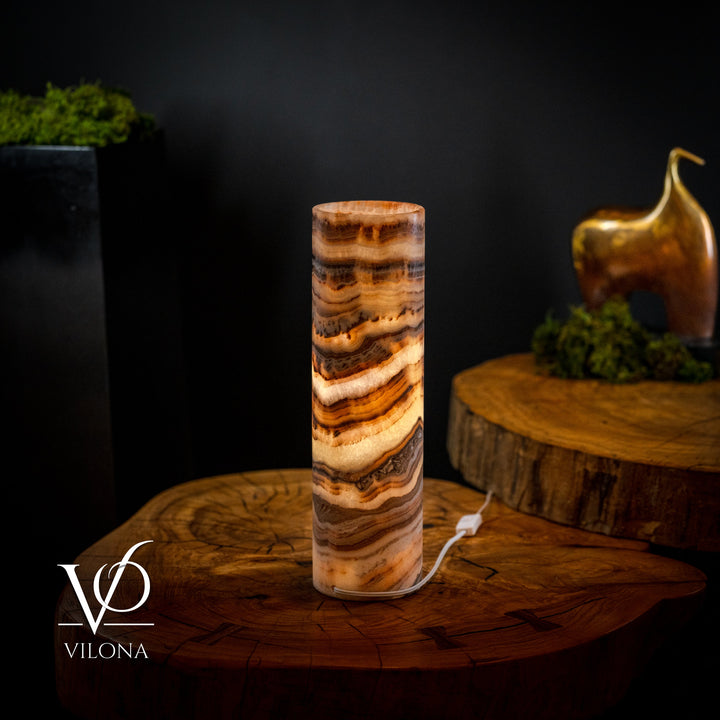 Cylindrical onyx crystal table lamp with visible power cord and amber stone patterns