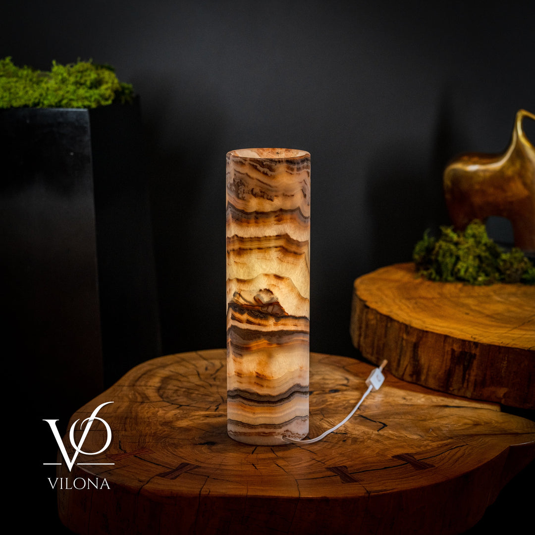 Sahara onyx cylinder table lamp with dark brown, tan, and cream striations, white cord