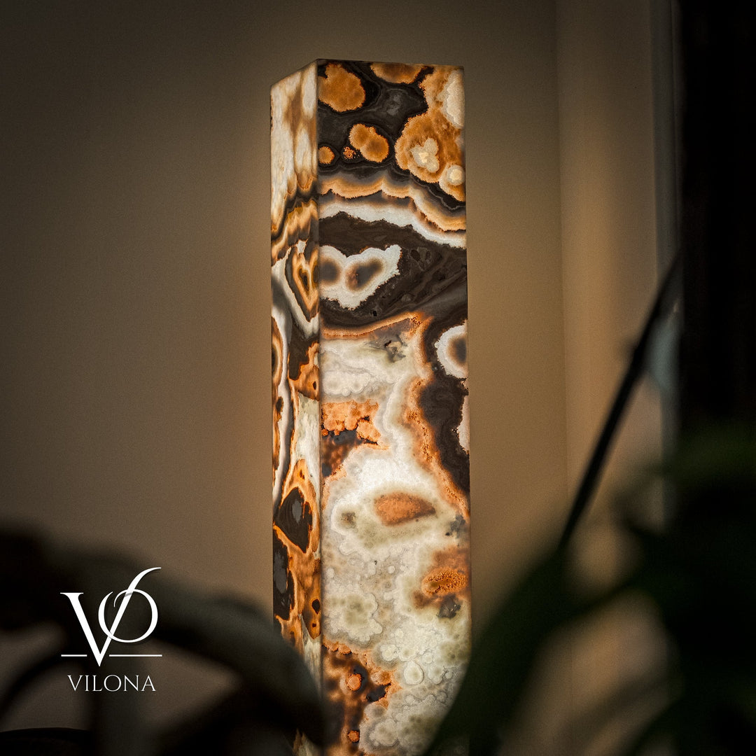 Close-up of polished onyx floor lamp stone column in cream, black, and warm amber tones