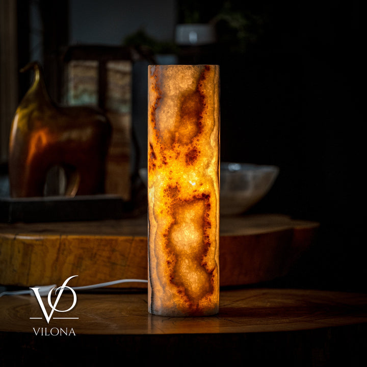 Cylindrical table lamp with amber onyx-style pattern and white power cord