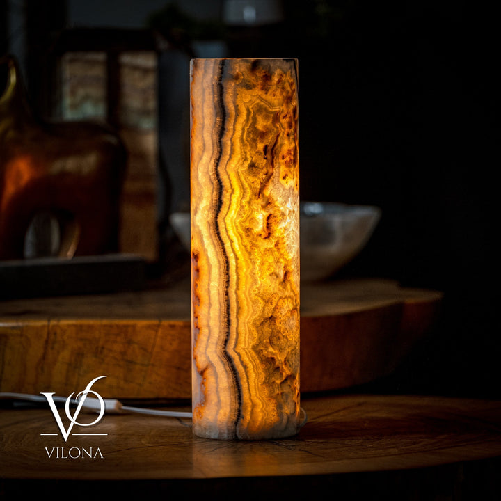 Cylindrical table lamp with vertical amber onyx bands and textured surface