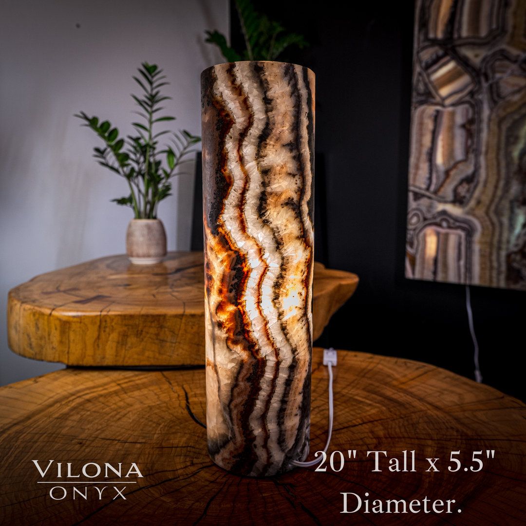 Onyx cylinder table lamp with vertical wavy stone pattern and warm glowing light.