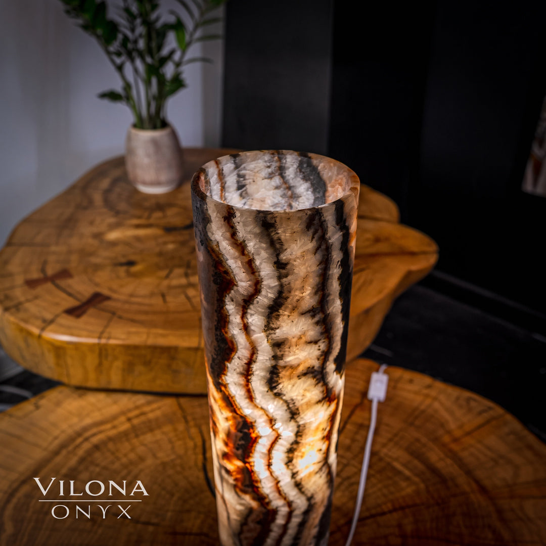 Onyx cylinder table lamp with open-top cylinder and glowing vertical amber pattern.
