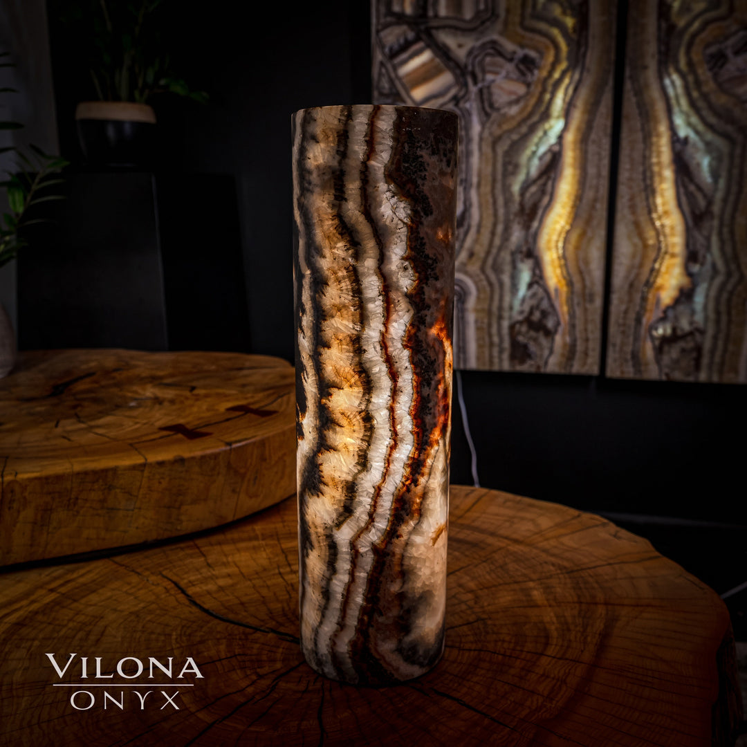 Tall onyx cylinder table lamp with dark base and bright glowing wavy stone lines.