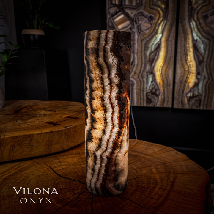 Tall onyx cylinder table lamp with dark base and bright glowing wavy stone lines.