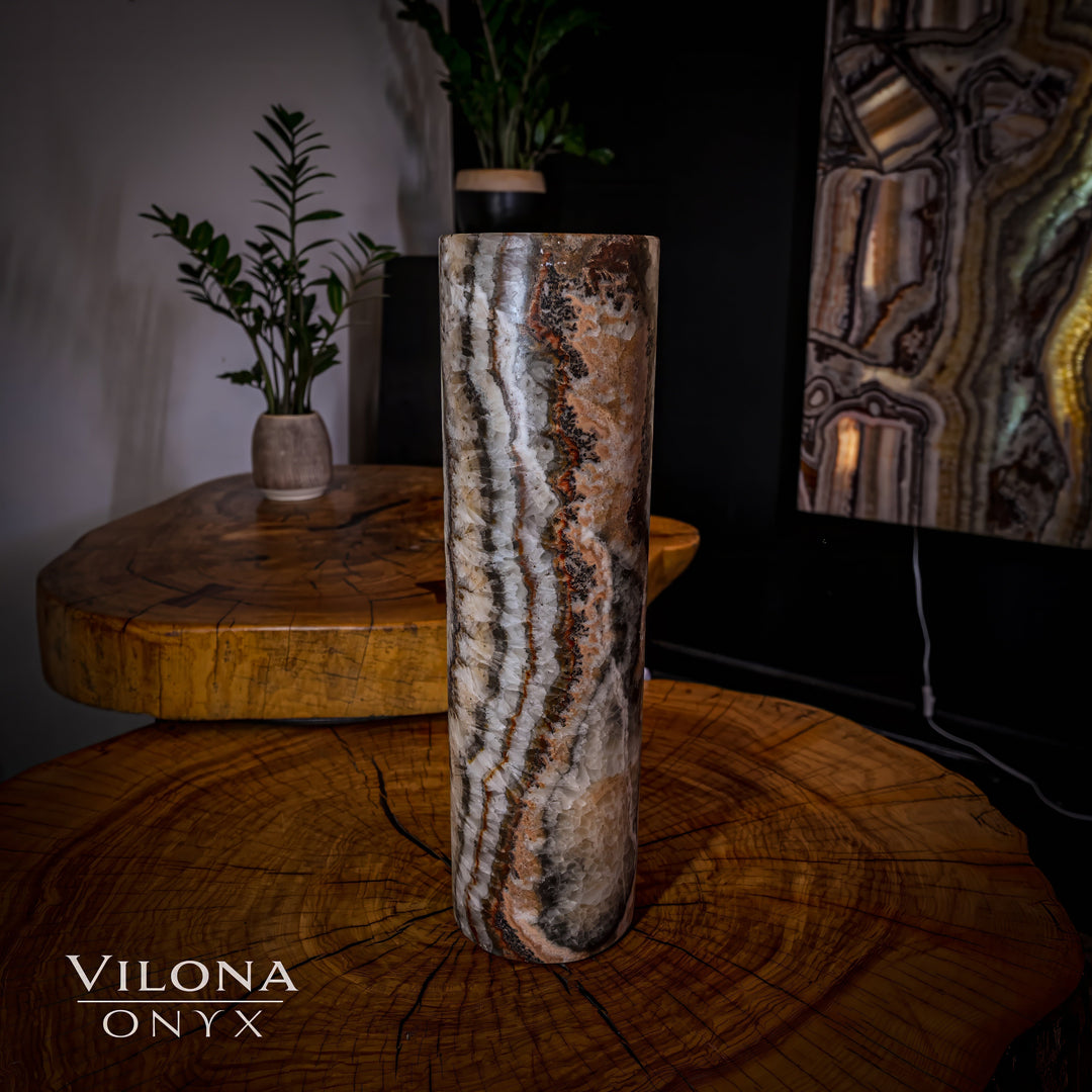 Tall onyx cylinder table lamp with dark-stone cylinder and glowing wavy vein pattern.