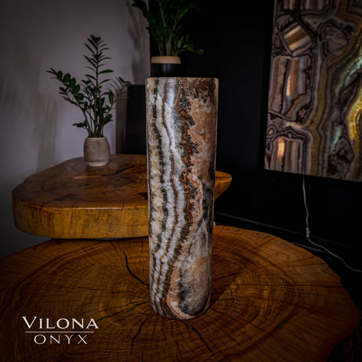 Tall onyx cylinder table lamp with dark-stone cylinder and glowing wavy vein pattern.