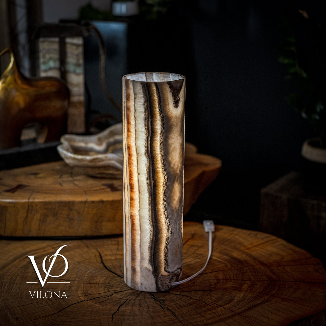 Cylinder table lamp with glowing core and dark onyx streaks on cream base