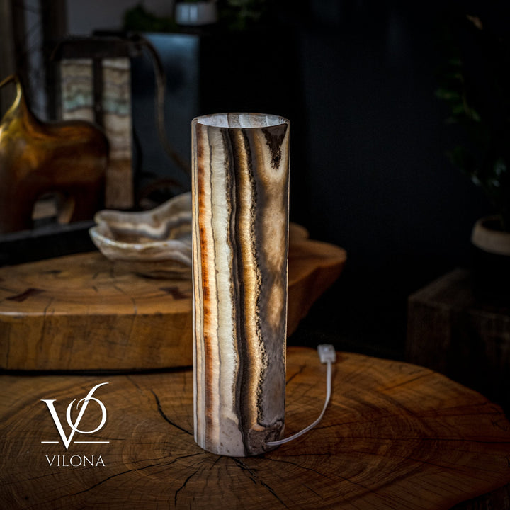 Cylinder table lamp with glowing core and dark onyx streaks on cream base