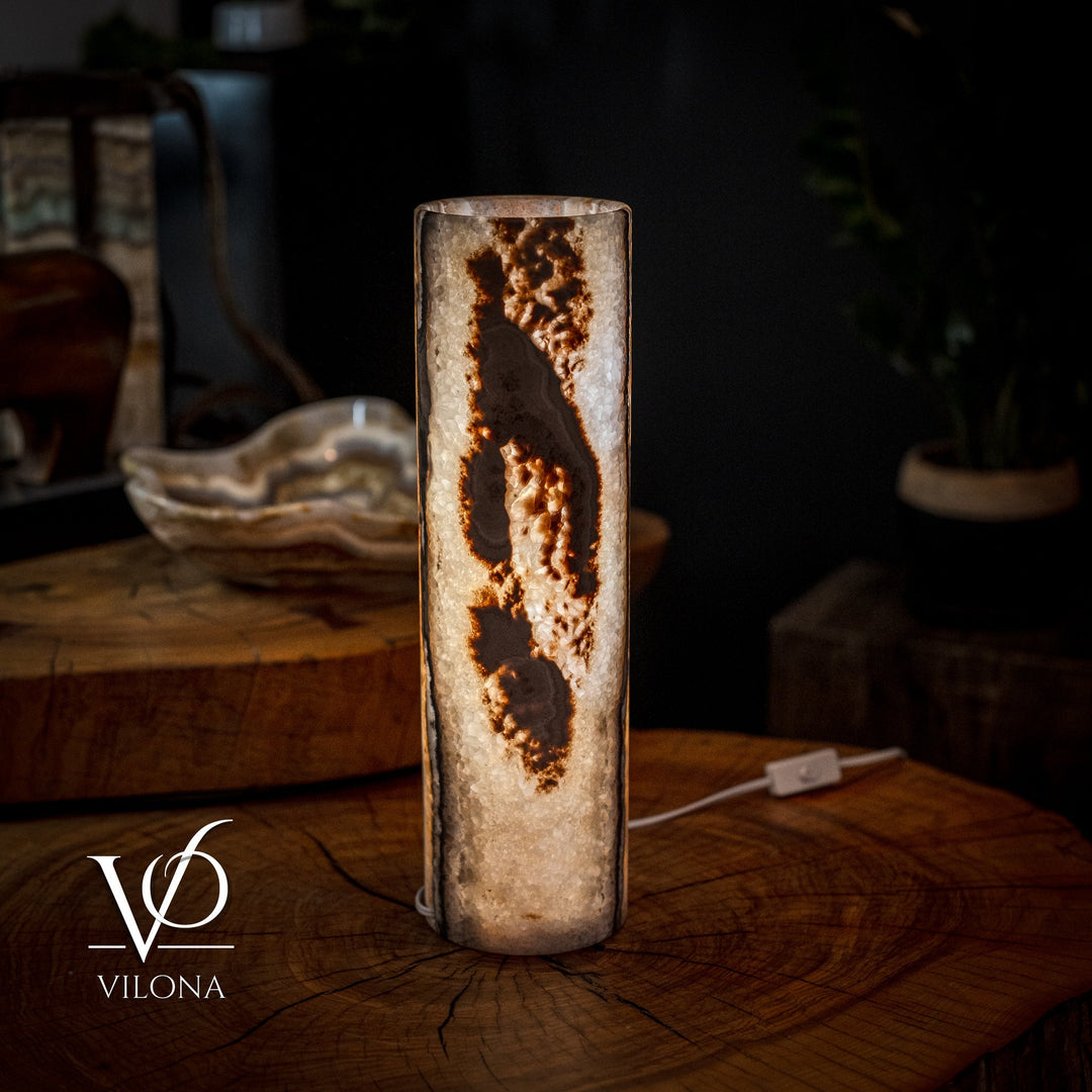 Cylinder table lamp with tall stone-like body and amber veining, warm lit center