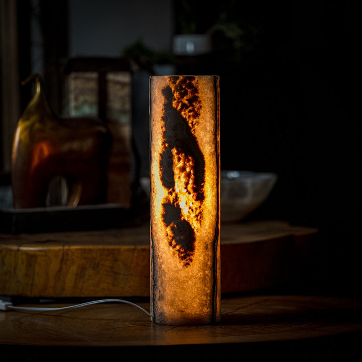 Cylinder table lamp with dark onyx-style texture and glowing amber patterns