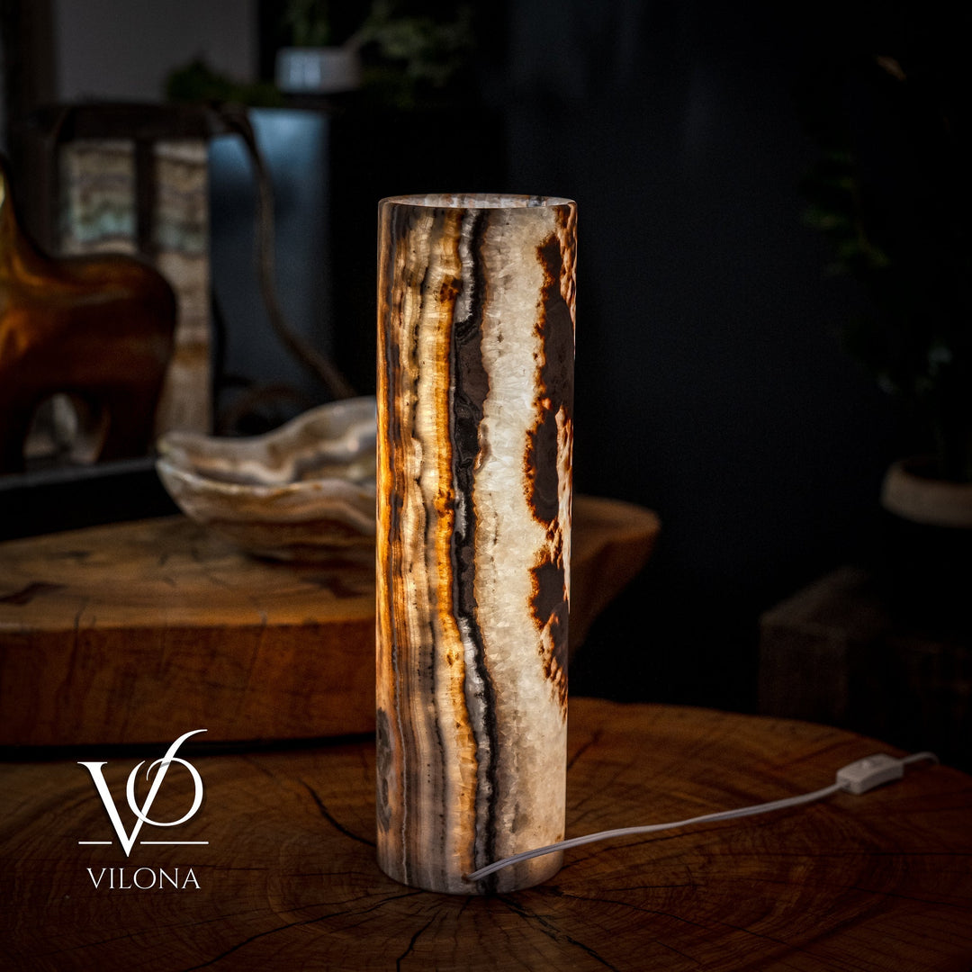 Cylinder table lamp with glowing amber core and visible white power cord