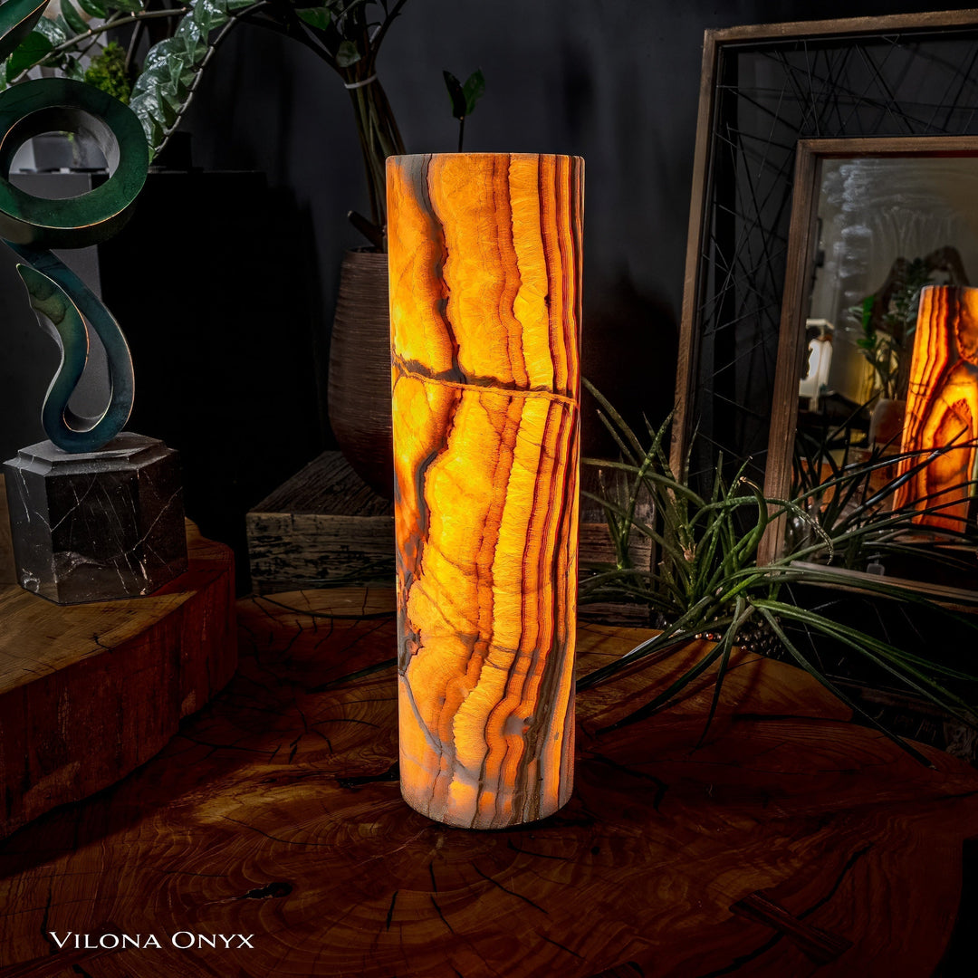 Cylinder table lamp with tall amber onyx-look shade, warm lit interior