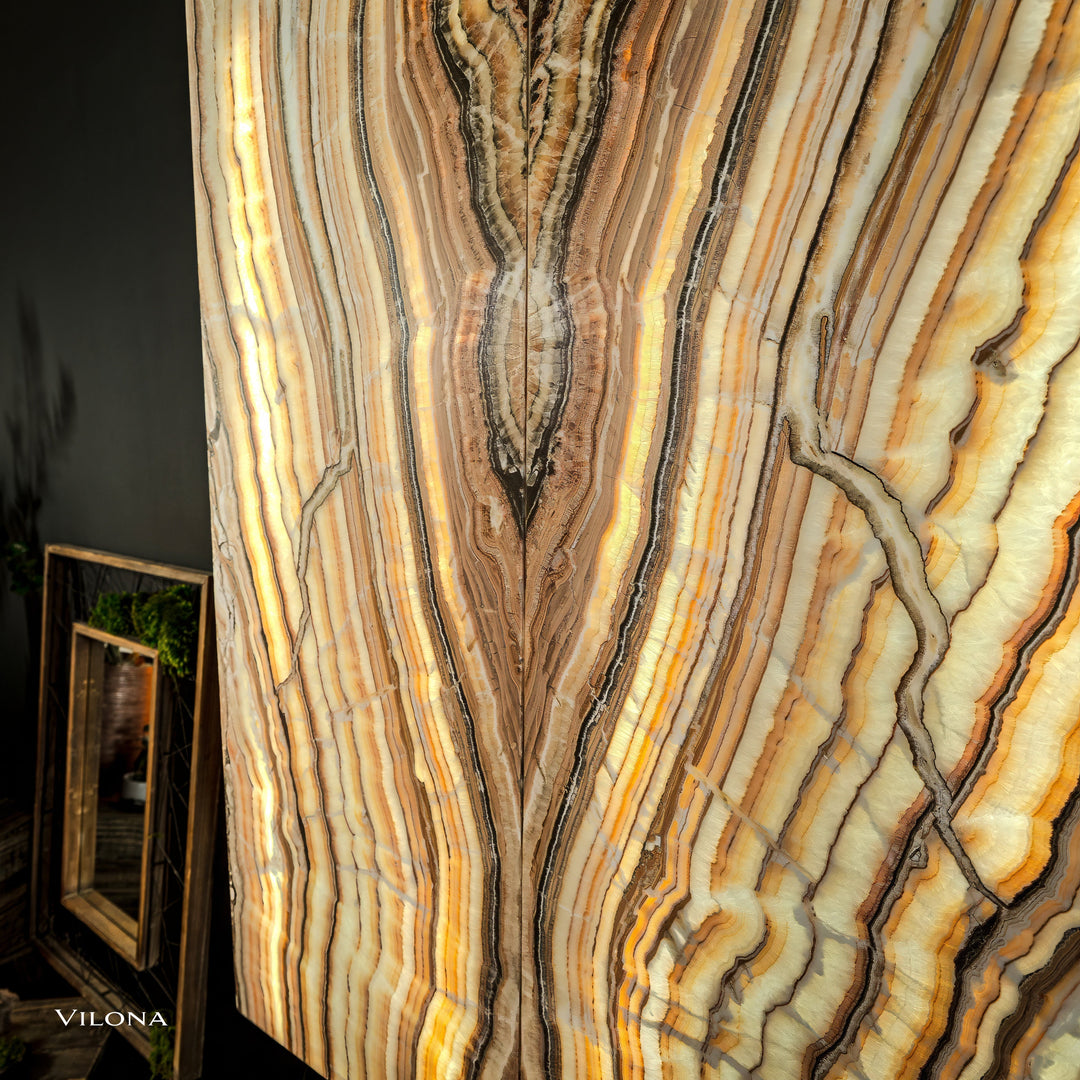 Onyx wall panel close-up showing branching lines in cream, gold, and dark brown