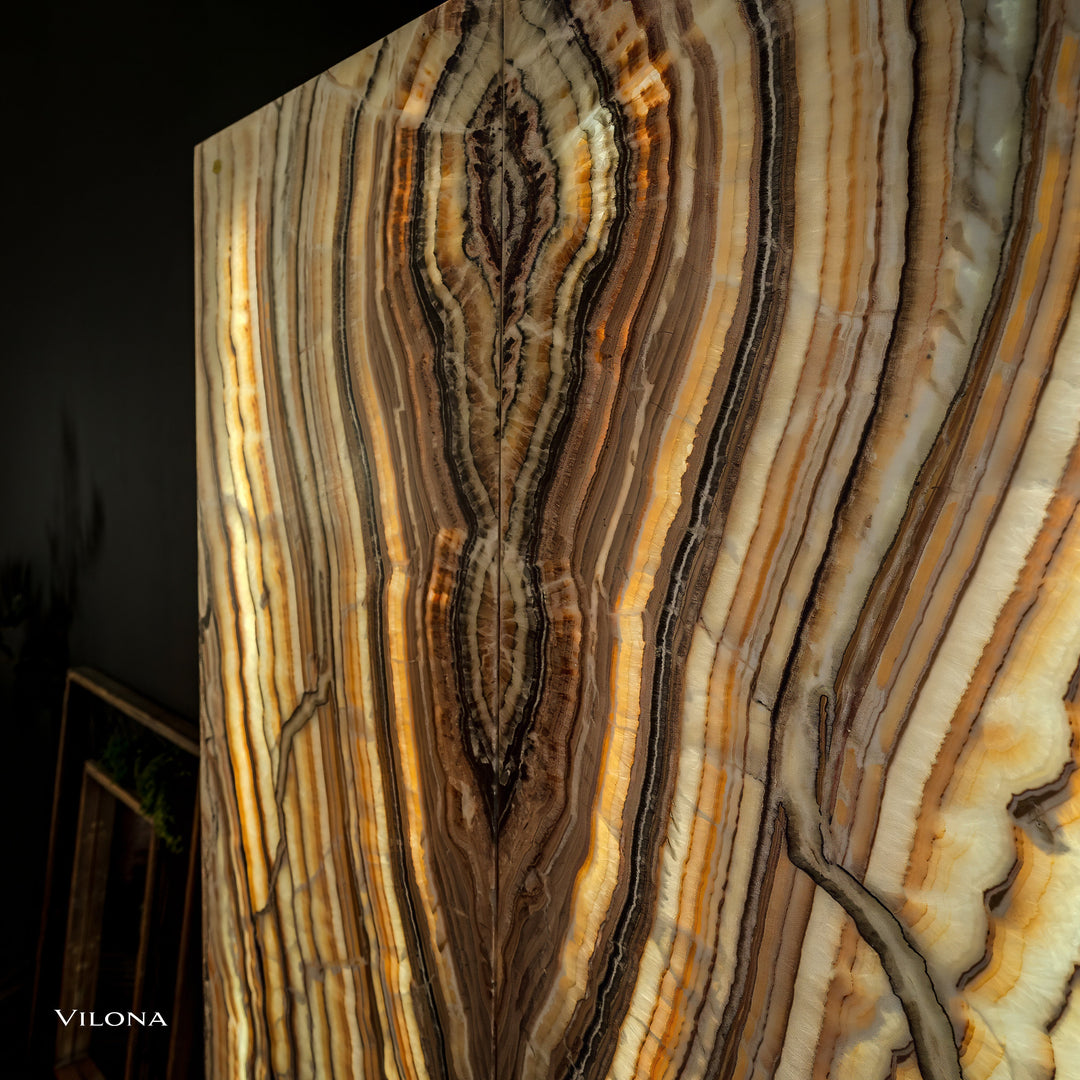 Onyx wall panel close-up detail with layered vertical striations in gold and cream