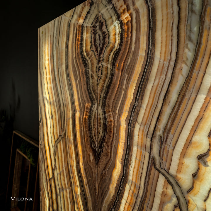 Onyx wall panel close-up detail with layered vertical striations in gold and cream