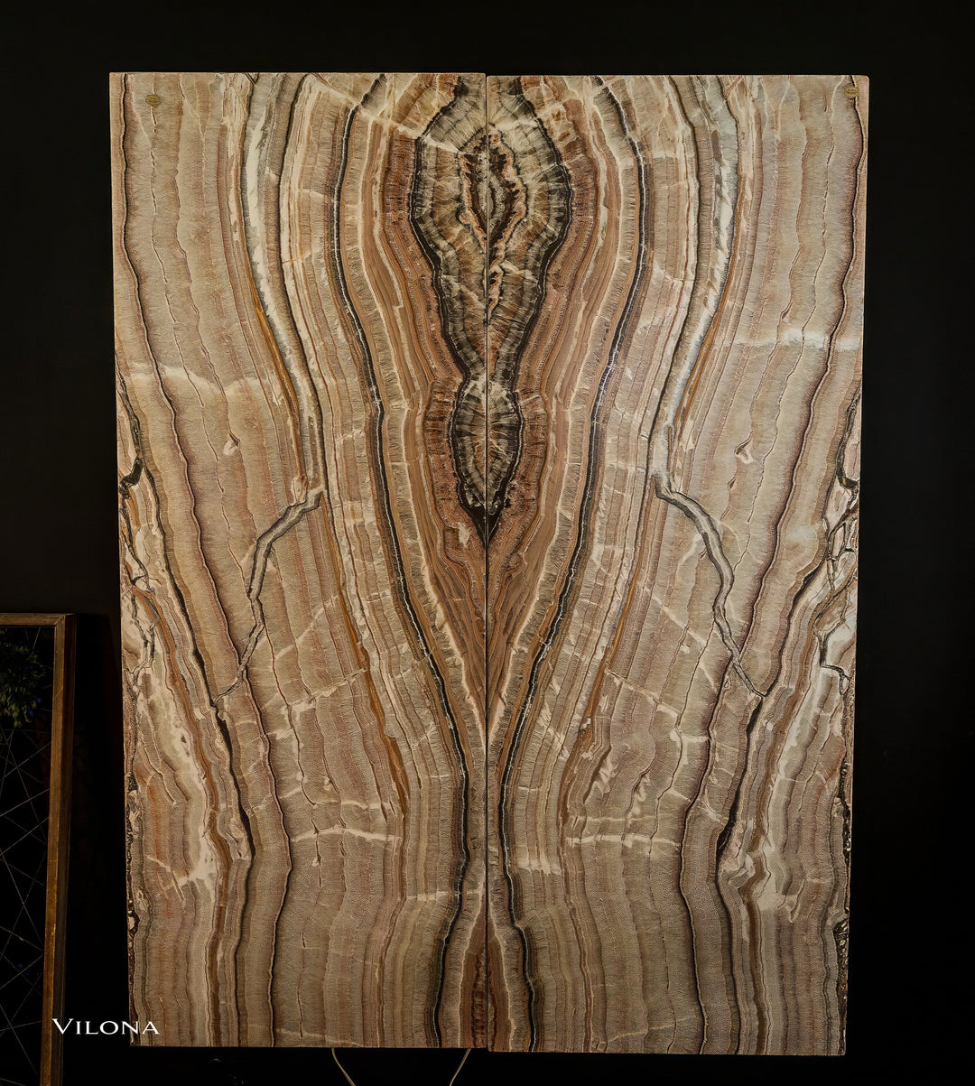 Onyx wall panel with symmetrical vertical veining in cream, gold, and dark brown