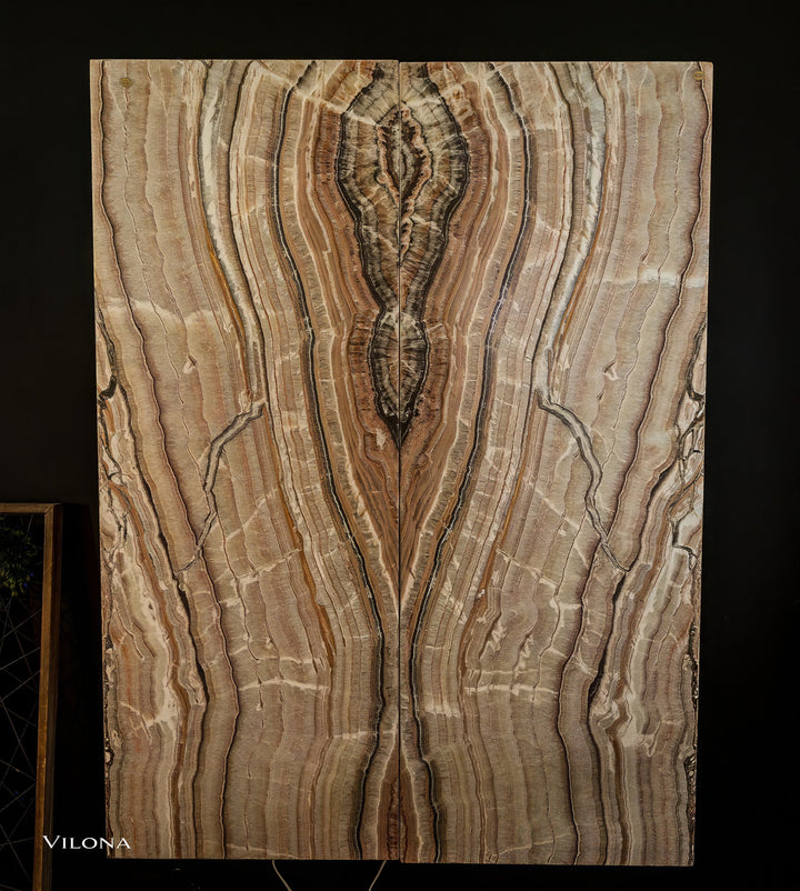 Onyx wall panel with symmetrical vertical veining in cream, gold, and dark brown