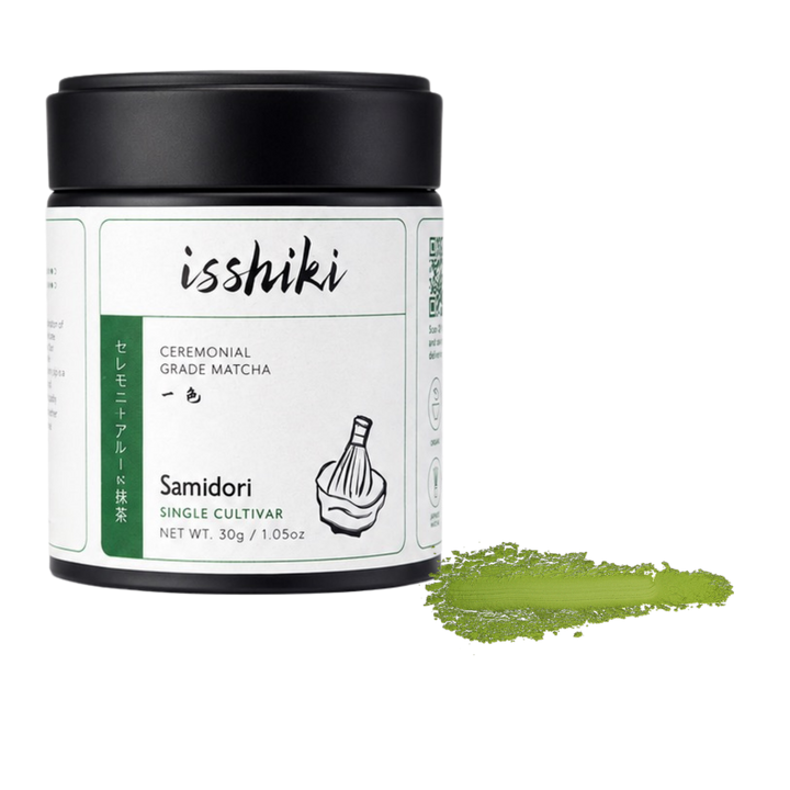 Ceremonial matcha powder jar with black lid and green label; matcha powder scoop beside it.