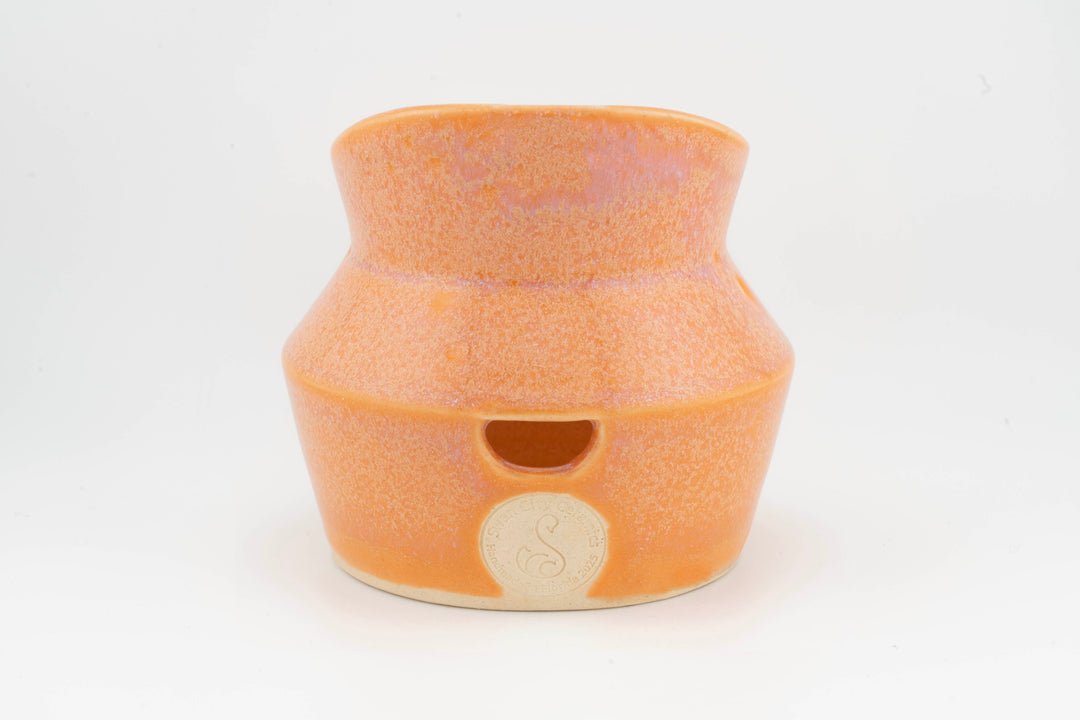 Ceramic dried flower sconce with side cutout, orange glaze with small medallion badge