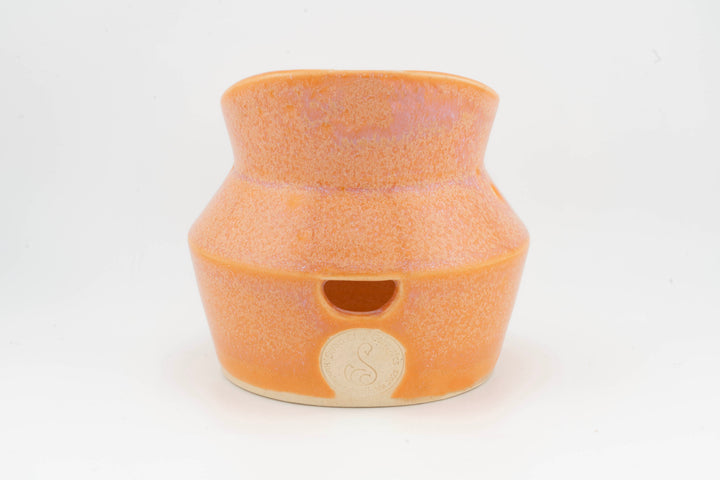 Ceramic dried flower sconce with side cutout, orange glaze with small medallion badge