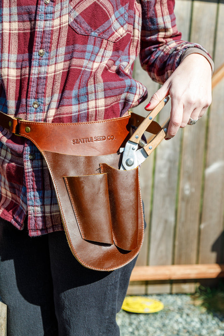 Brown leather tool belt worn on waist with two large front pockets