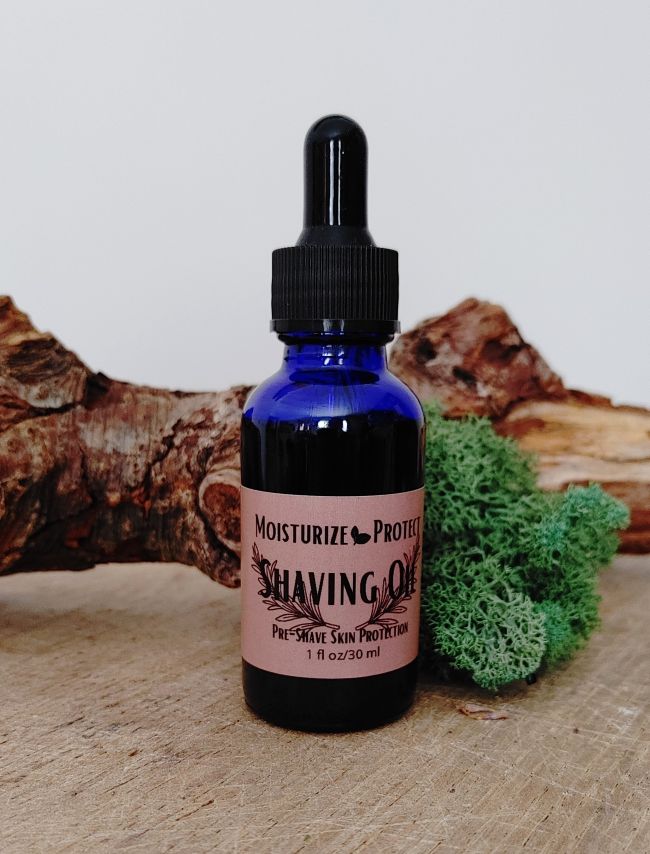 Blue glass shaving oil bottle with black dropper and moisturizing-protecting label