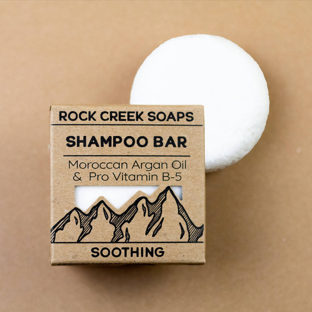 Soothing shampoo bar and box with mountain graphic; white round bar