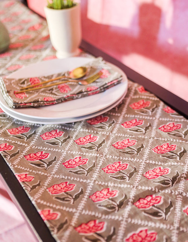 Olive linen table runner spread flat with repeating pink-red floral print