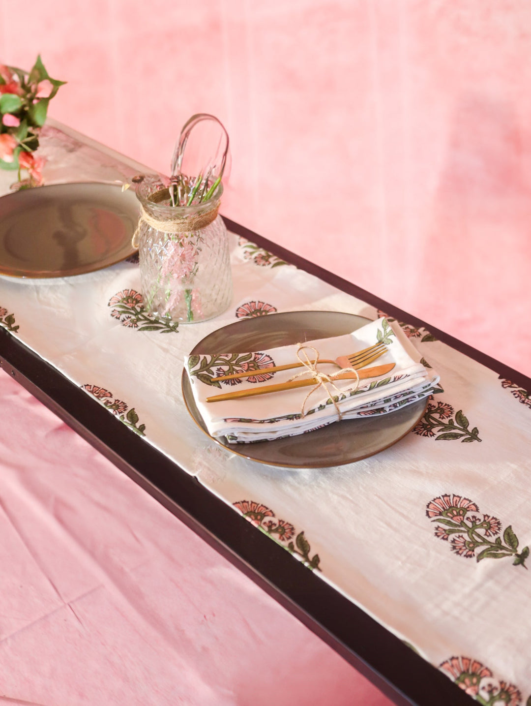 Linen hand-printed runner with a floral border and motifs on pale pink