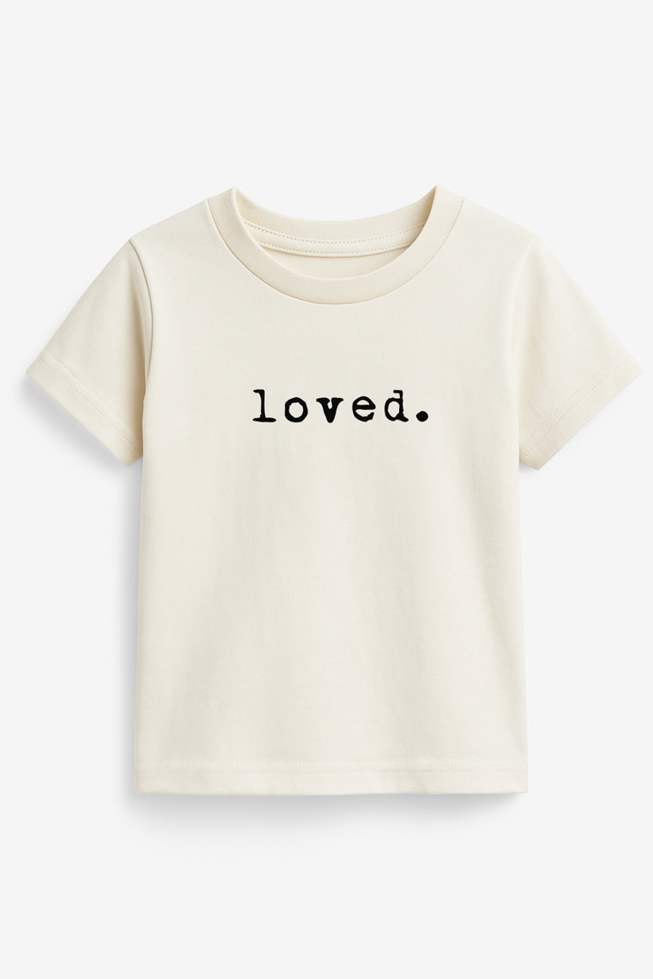 Cream kids organic T-shirt with “loved.” text print at center chest