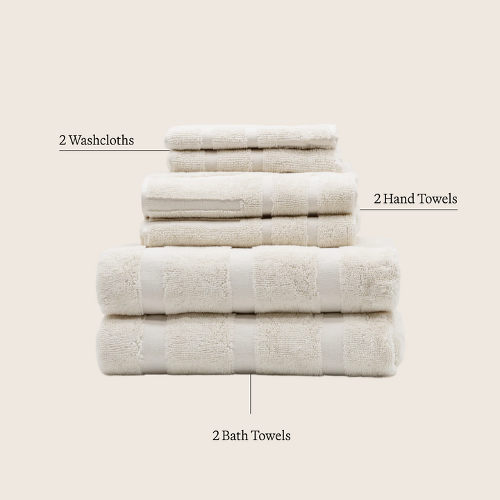 Cotton towel set in ecru: washcloths, hand towels, and bath towels stacked