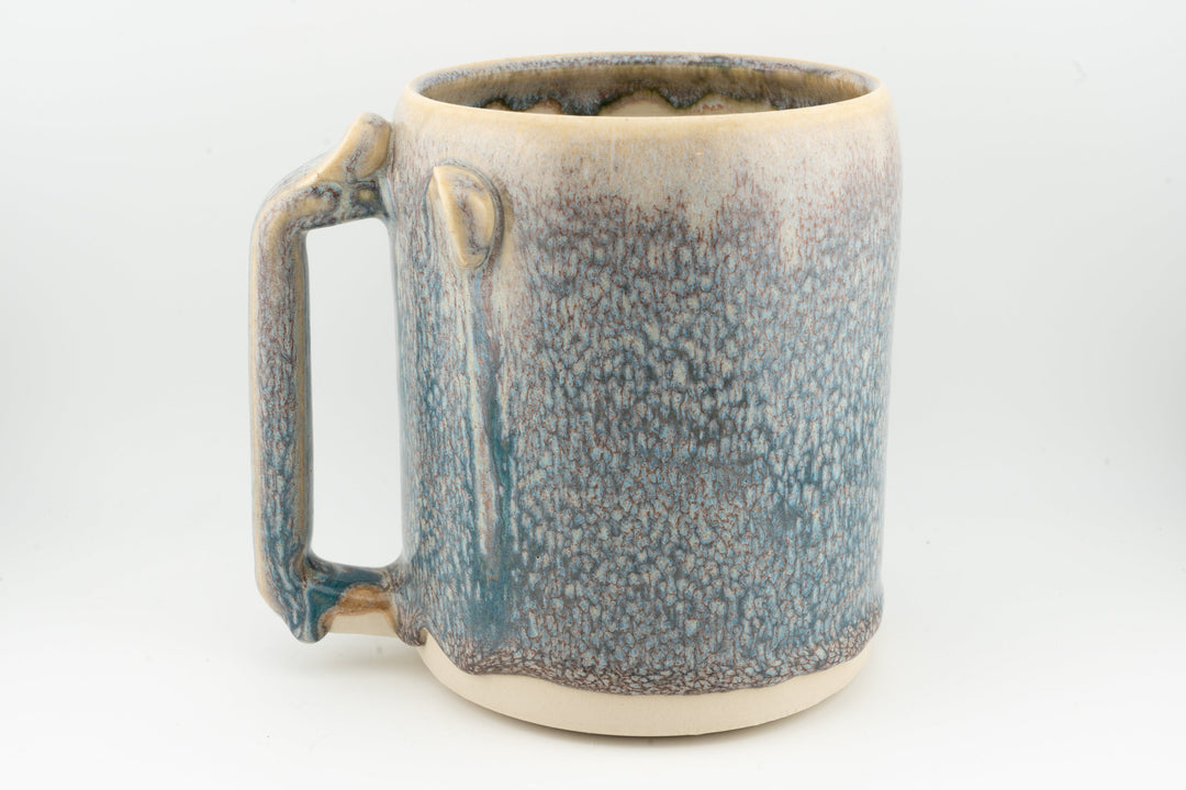 Blue speckled ceramic stein mug, side handle and caramel-brown rim