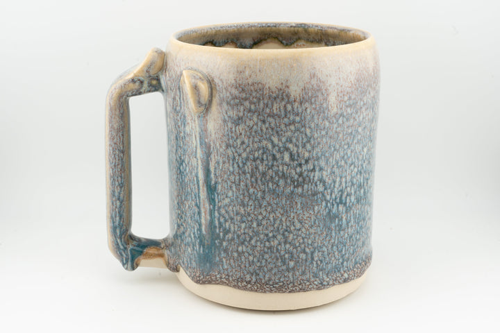 Blue speckled ceramic stein mug, side handle and caramel-brown rim