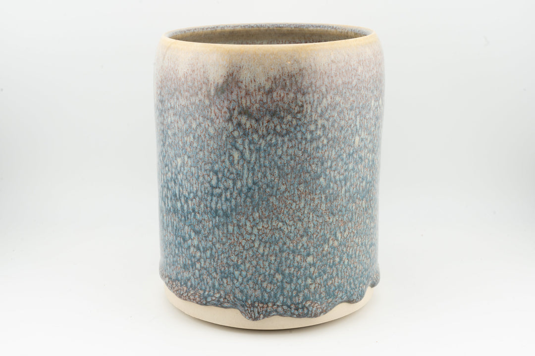 Blue speckled ceramic stein mug with caramel-brown rim and rounded base