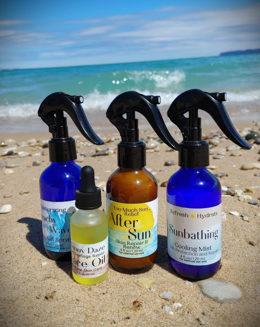 After sun spray set of three bottles with black mist nozzles, blue and amber liquids.