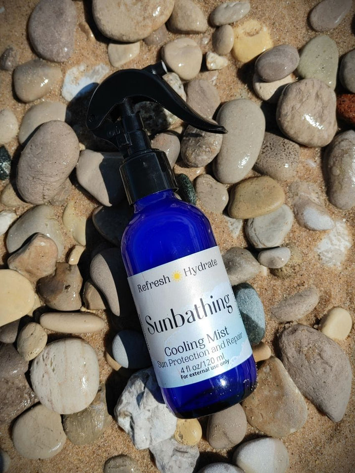 Blue body mist bottle angled view with black spray nozzle and &