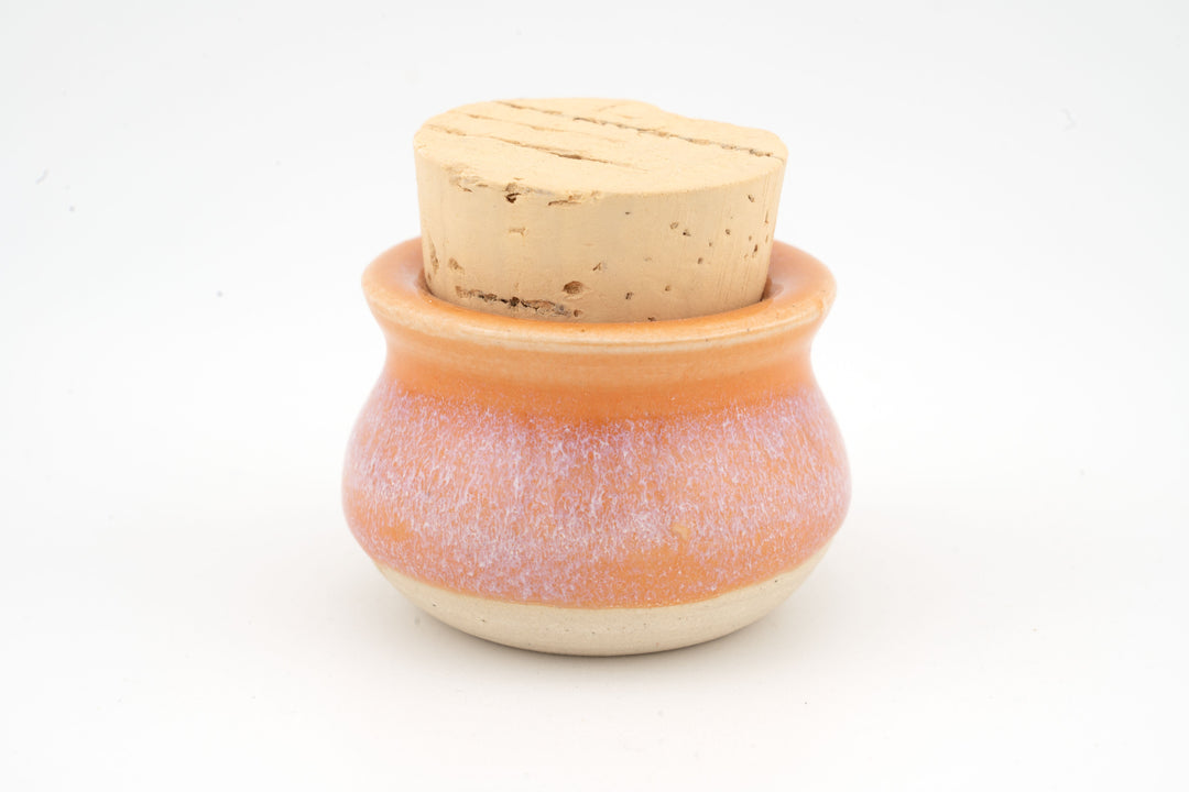 Mini corked jar with orange ceramic glaze and natural cork lid.