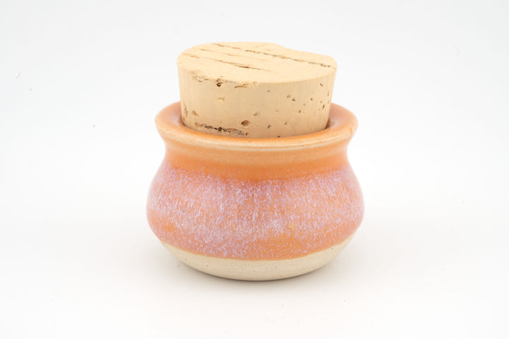 Mini corked jar with orange ceramic glaze and natural cork lid.